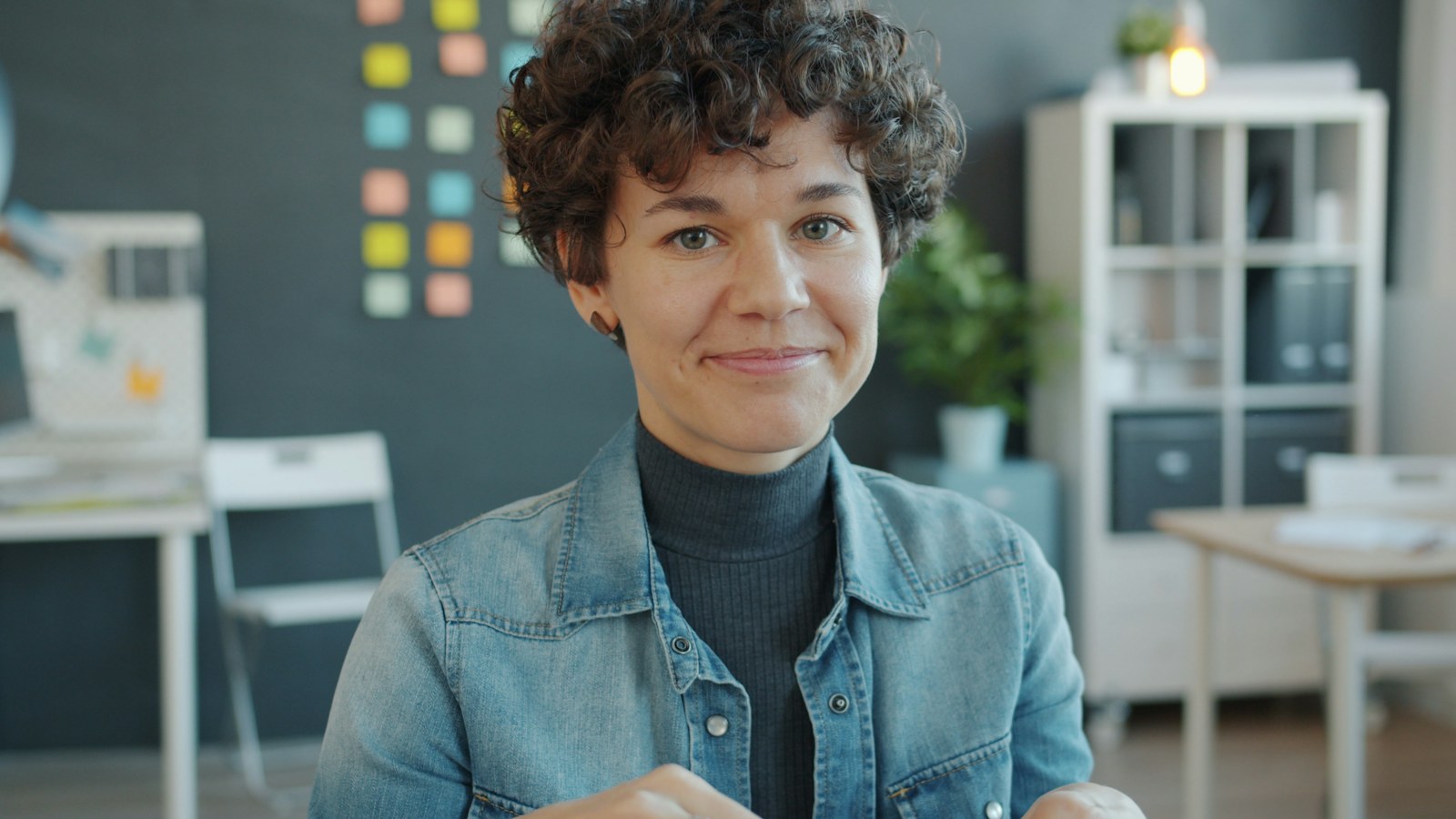 Collaboratrice face caméra lors d’une interview dans ses bureaux