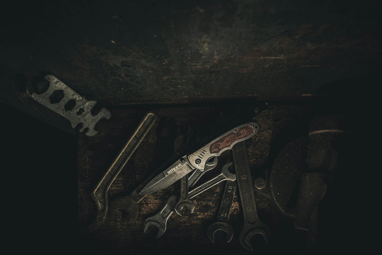 Couteau pliant photographié en gros plan parmi des outils